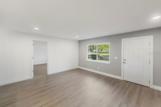 interior space featuring recessed lighting, baseboards, and light wood finished floors