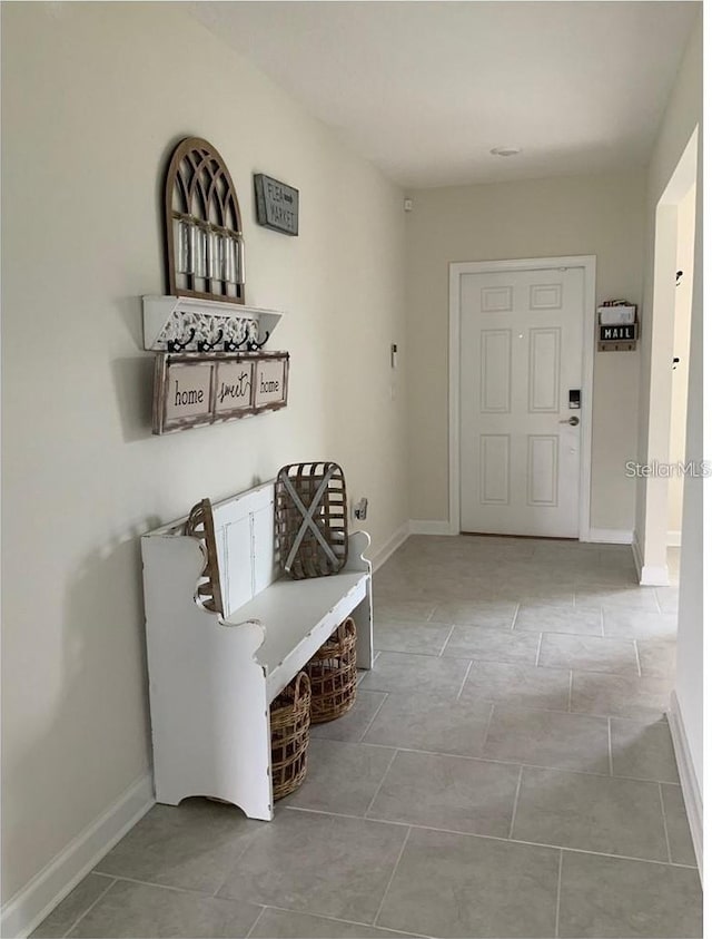 hallway with tile patterned floors and baseboards