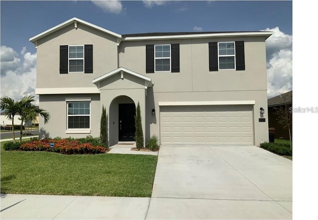 view of front of house featuring a front lawn, a garage, driveway, and stucco siding