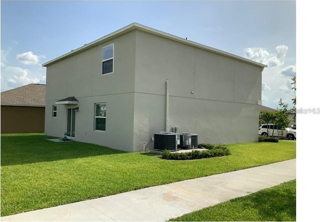 view of property exterior with a yard, cooling unit, and stucco siding