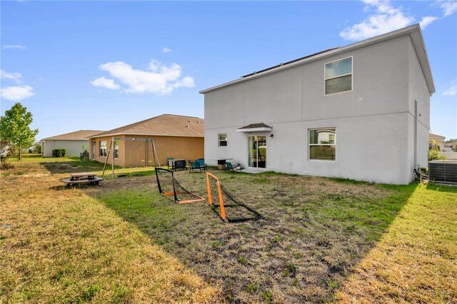 204 Taft Dr, Davenport, FL 33837 - back of property with stucco siding, a lawn, and central air condition unit