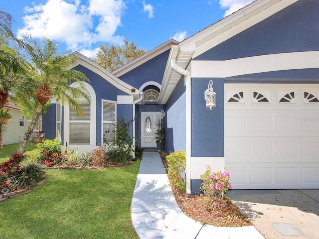 doorway to property featuring stucco siding, a garage, and a yard