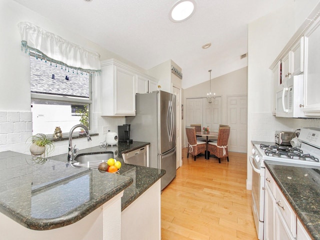 kitchen with backsplash, light wood-type flooring, appliances with stainless steel finishes, and a sink