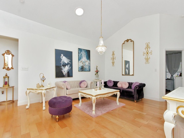 living area with baseboards, lofted ceiling, and light wood finished floors