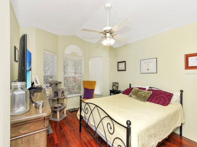 bedroom with a ceiling fan, lofted ceiling, wood finished floors, and baseboards