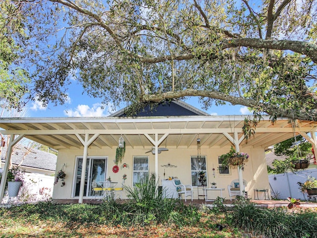 exterior space featuring covered porch, stucco siding, and a ceiling fan