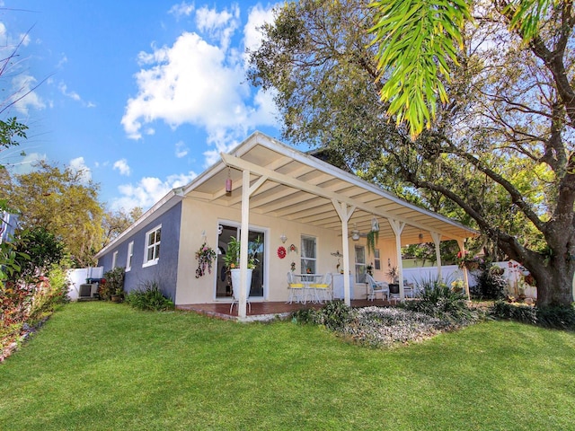 view of front of house with a front lawn, central air condition unit, a porch, and stucco siding