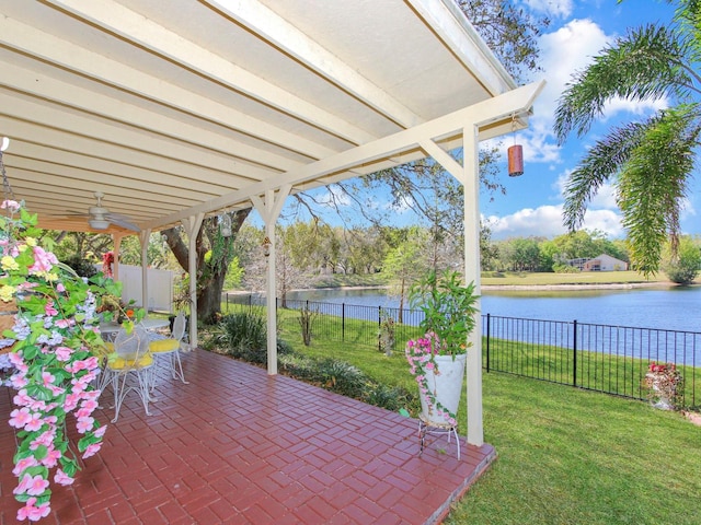 view of patio featuring outdoor dining space, a fenced backyard, and a water view