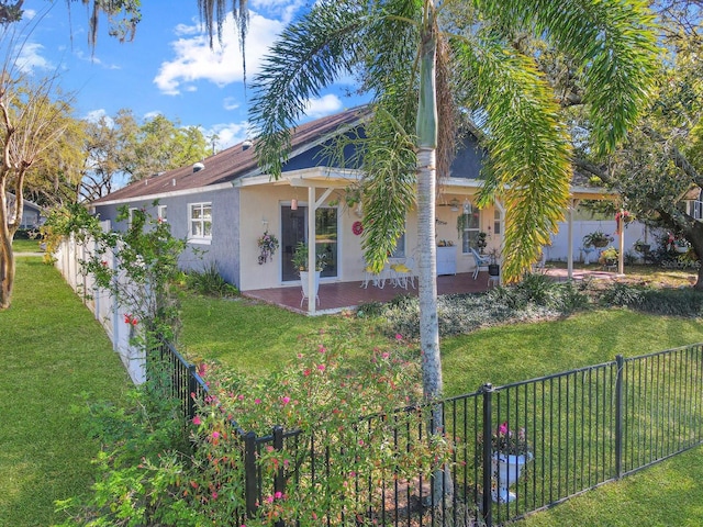 exterior space featuring stucco siding, a fenced backyard, and a front lawn