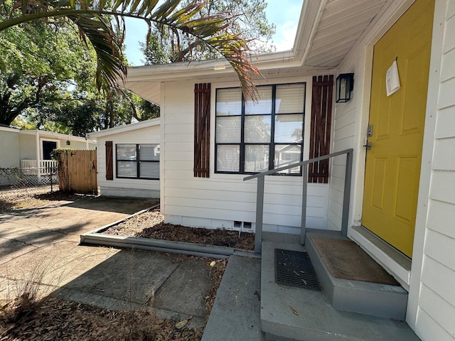 property entrance with crawl space and fence