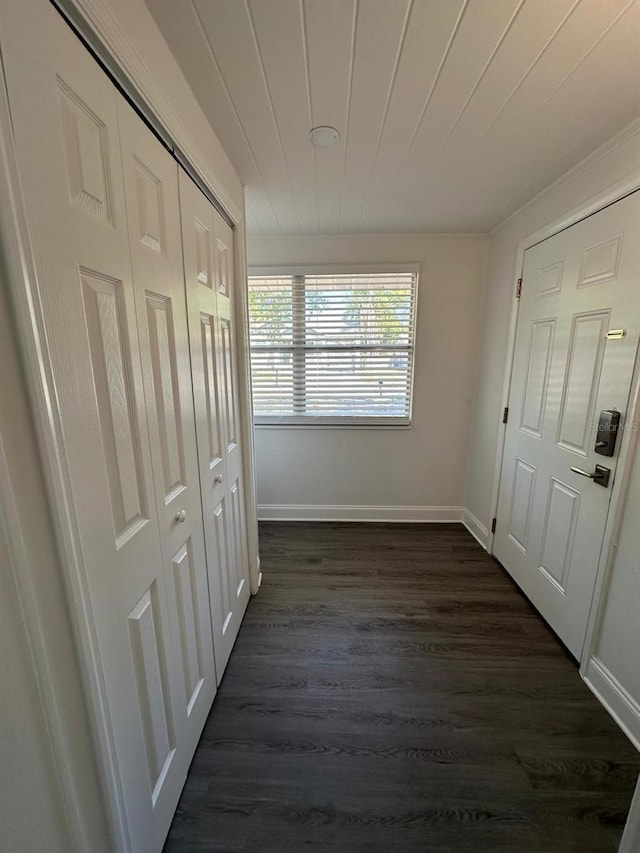 interior space with dark wood-type flooring, baseboards, and wooden ceiling