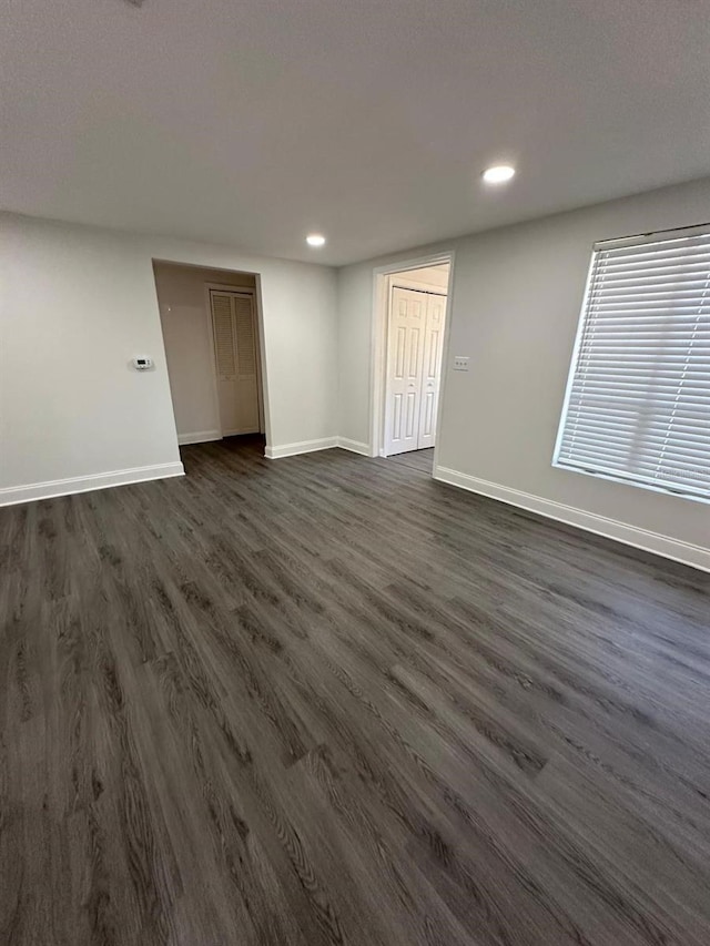 unfurnished room with recessed lighting, dark wood-style floors, and baseboards