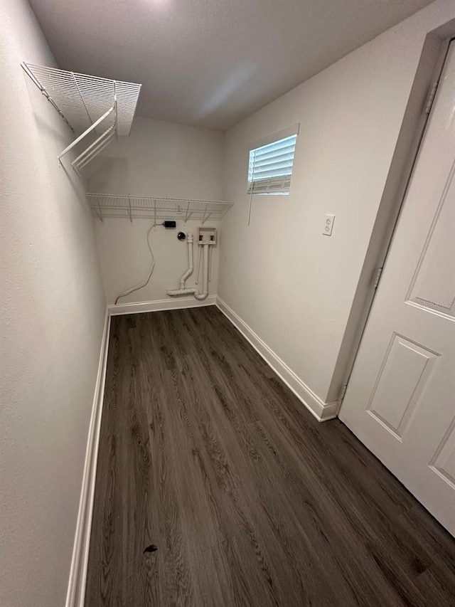 clothes washing area with baseboards, dark wood-type flooring, hookup for a washing machine, and laundry area