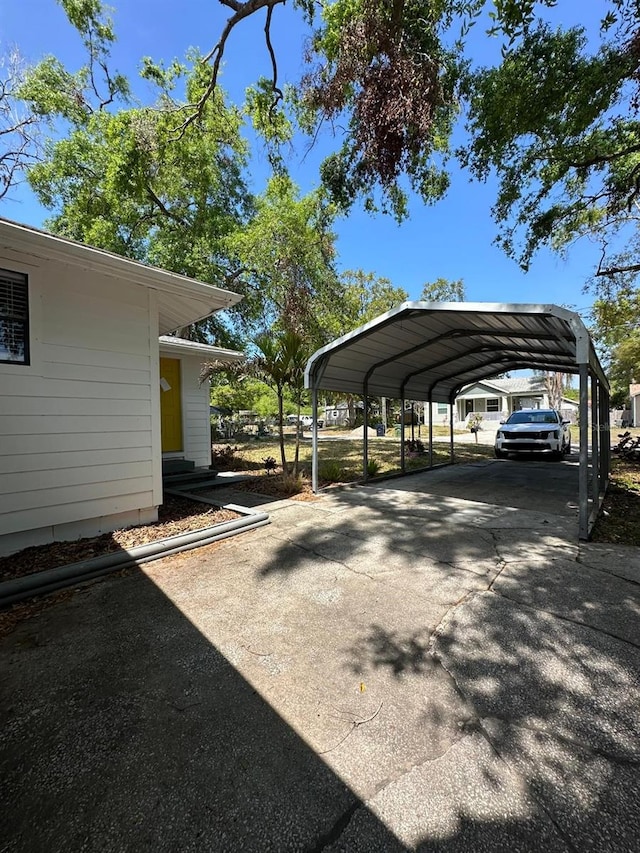 view of car parking featuring aphalt driveway and a detached carport