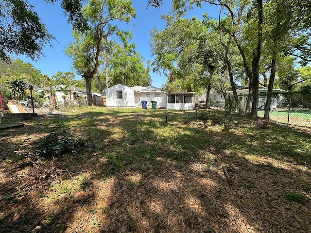 view of yard with fence and a sunroom