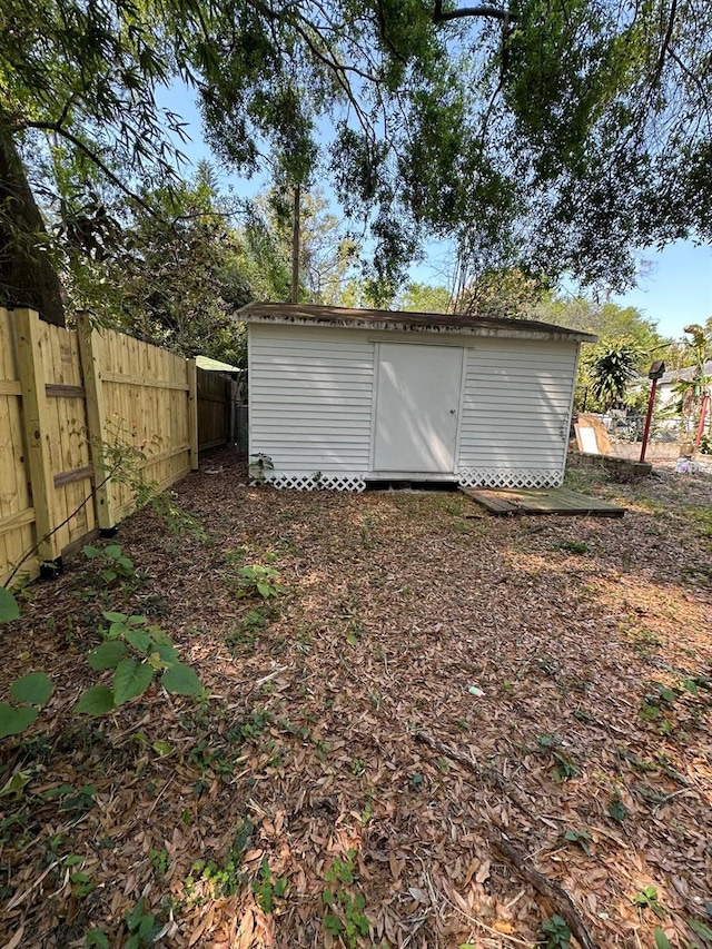 garage with fence and a shed