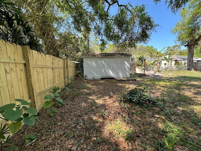 view of yard featuring a fenced backyard, an outdoor structure, and a shed