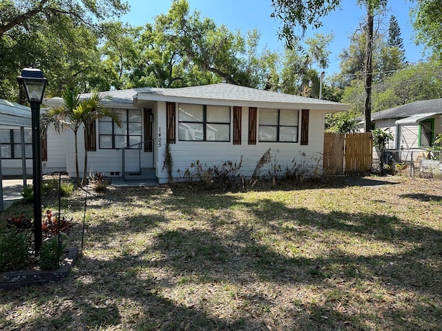 view of front of house with entry steps, a front lawn, and fence