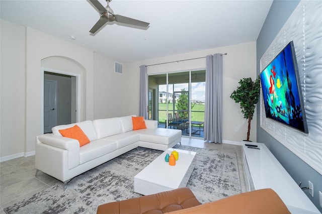 living area featuring light tile patterned floors, baseboards, and a ceiling fan