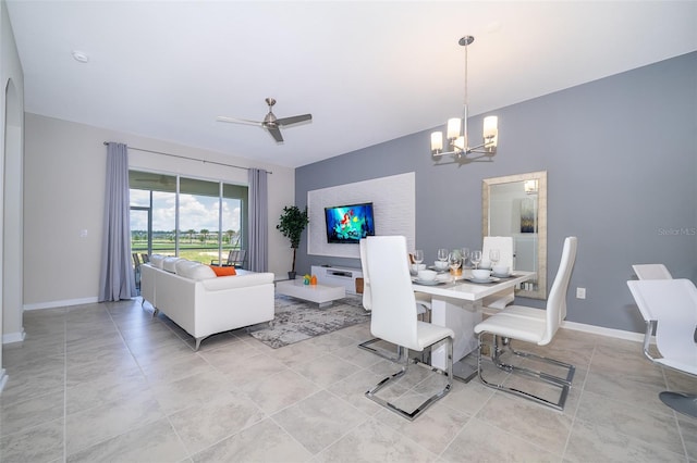 dining room featuring light tile patterned floors, ceiling fan with notable chandelier, and baseboards