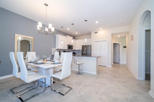 dining room featuring visible vents, baseboards, recessed lighting, arched walkways, and a notable chandelier