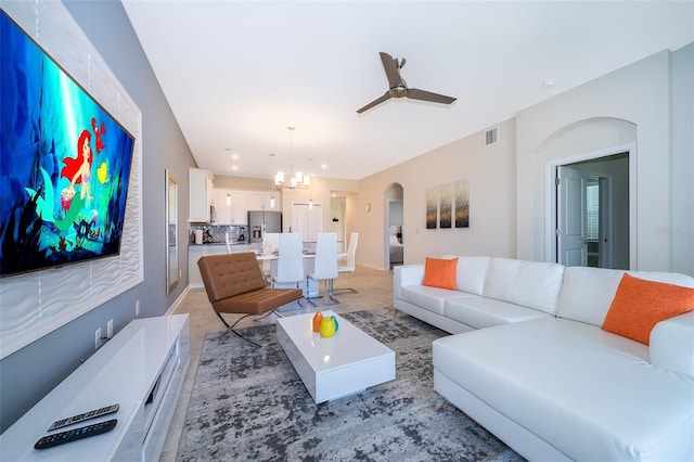 living area featuring arched walkways, visible vents, and ceiling fan with notable chandelier