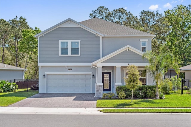 craftsman inspired home featuring fence, a front yard, stucco siding, decorative driveway, and a garage