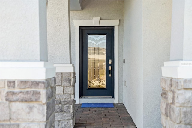 entrance to property with stucco siding