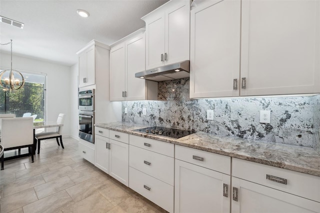 kitchen with stainless steel double oven, white cabinets, under cabinet range hood, black electric stovetop, and a chandelier