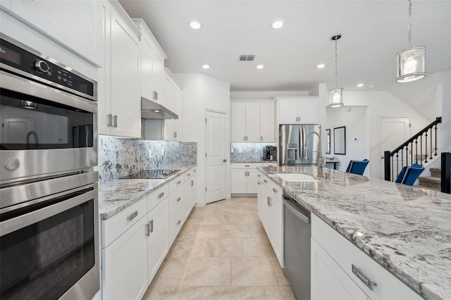 kitchen featuring visible vents, backsplash, under cabinet range hood, appliances with stainless steel finishes, and white cabinetry