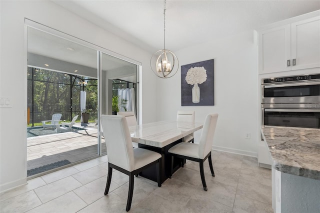 dining room with light tile patterned floors, baseboards, and a chandelier