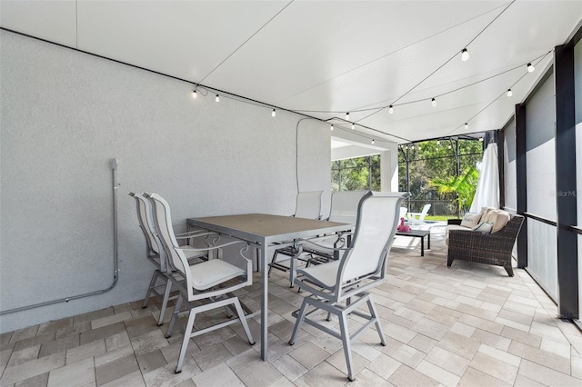 view of patio / terrace featuring a lanai and outdoor dining space