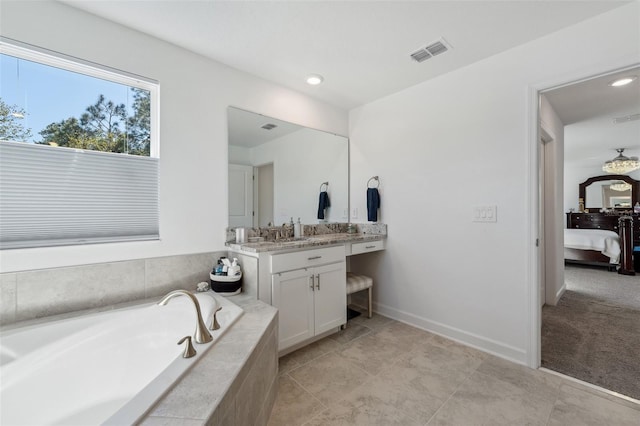 bathroom featuring visible vents, ensuite bath, baseboards, a bath, and vanity