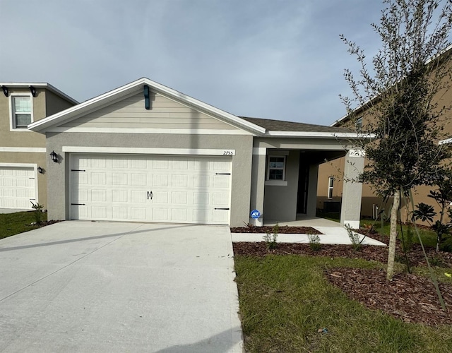 view of front facade featuring stucco siding, an attached garage, and concrete driveway