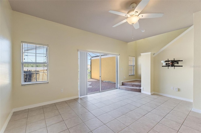 unfurnished bedroom featuring access to exterior, light tile patterned floors, a ceiling fan, and baseboards