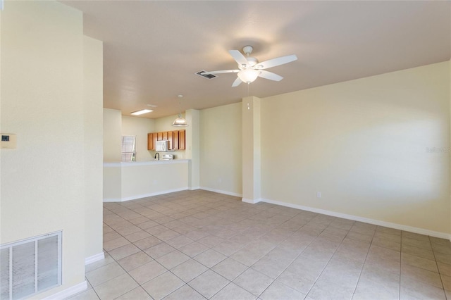 unfurnished living room with light tile patterned floors, visible vents, baseboards, and a ceiling fan