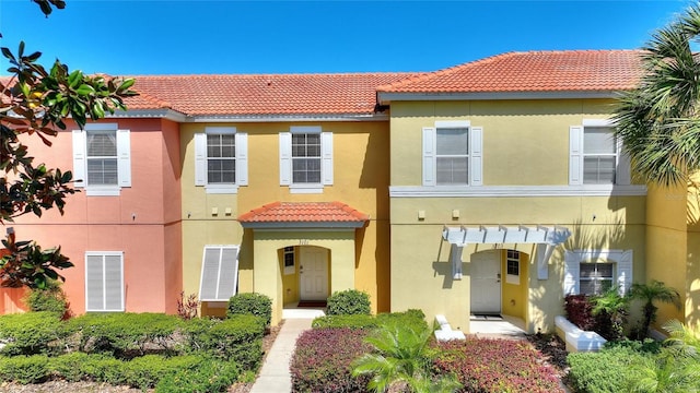 view of front facade with stucco siding and a tile roof