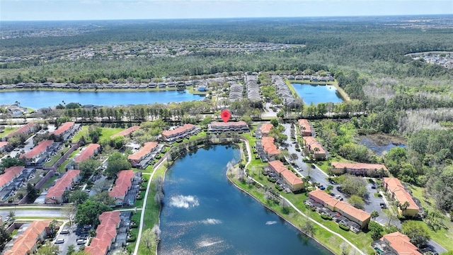 drone / aerial view with a forest view and a water view