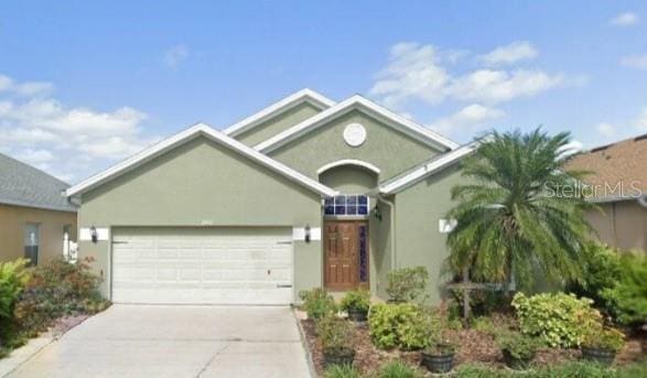 view of front of home featuring a garage, concrete driveway, and stucco siding