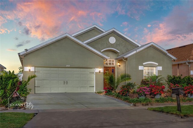 2102 Congress Ln, Saint Cloud, FL 34769 - view of front of home featuring stucco siding, driveway, and a garage