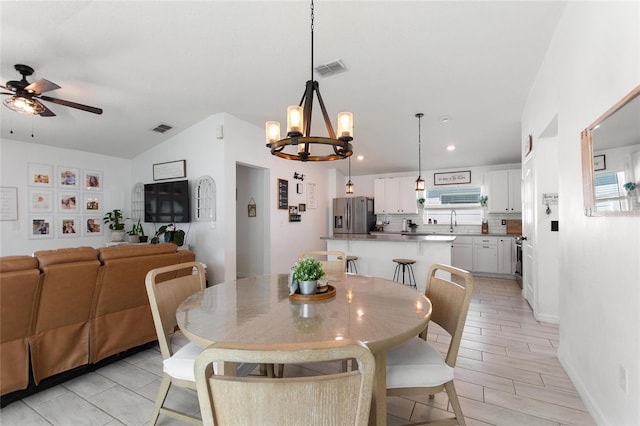 dining area featuring lofted ceiling, recessed lighting, ceiling fan with notable chandelier, and visible vents