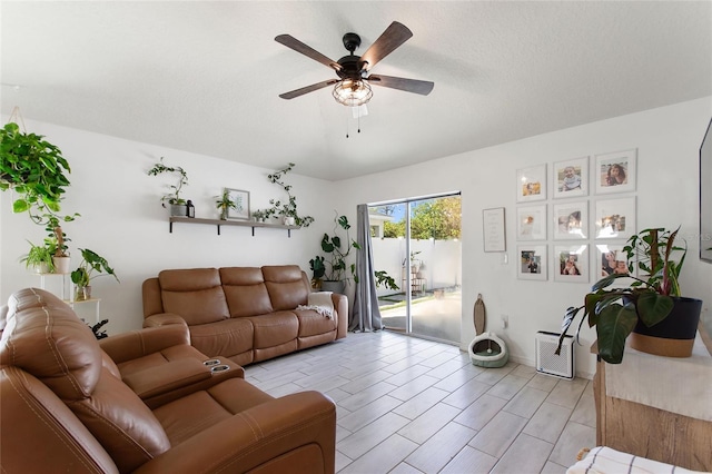 living room with a textured ceiling and ceiling fan