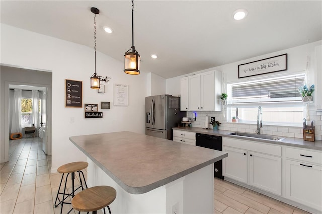 kitchen with a breakfast bar, stainless steel refrigerator with ice dispenser, a sink, backsplash, and dishwasher