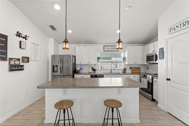 kitchen featuring a sink, a kitchen breakfast bar, visible vents, and stainless steel appliances