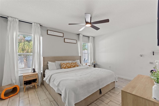 bedroom with a textured ceiling, a ceiling fan, and wood finish floors