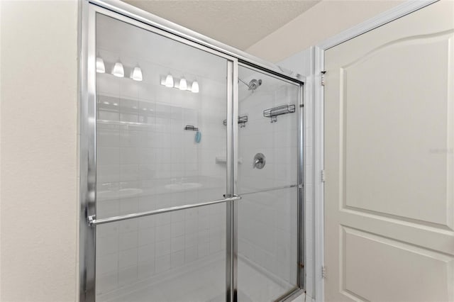 full bath with a stall shower and a textured ceiling