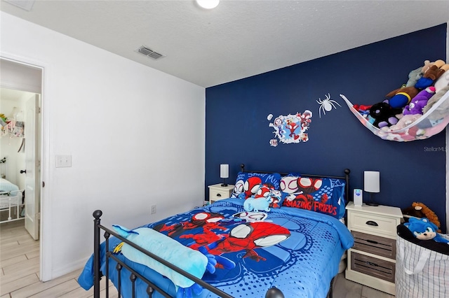 bedroom with visible vents and wood finished floors