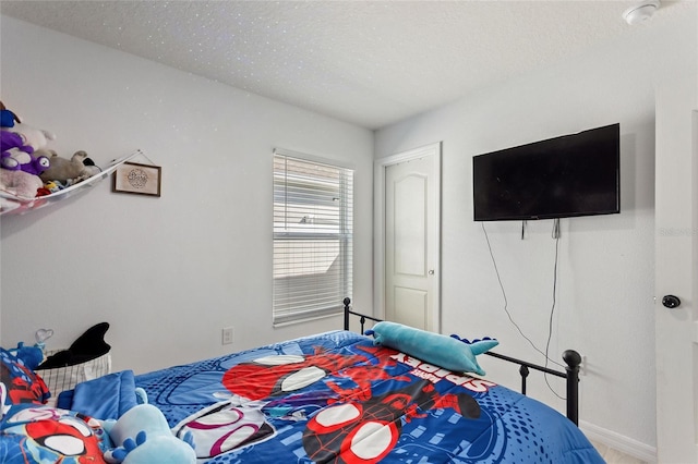 bedroom featuring baseboards and a textured ceiling