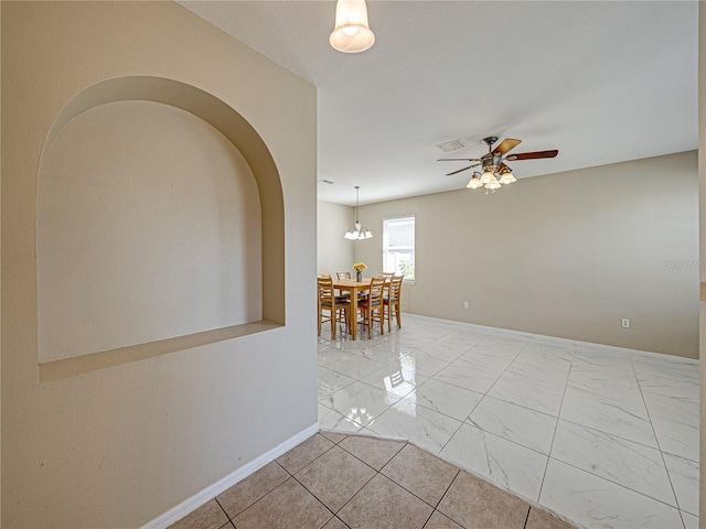 empty room with visible vents, baseboards, arched walkways, marble finish floor, and a ceiling fan