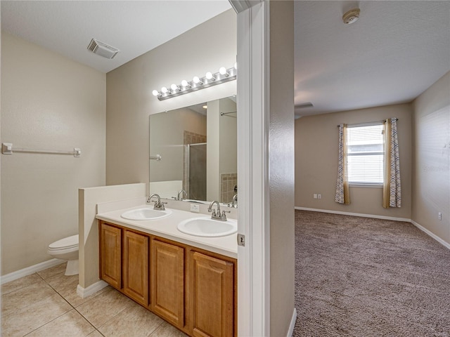 bathroom featuring tile patterned flooring, visible vents, a shower stall, and a sink